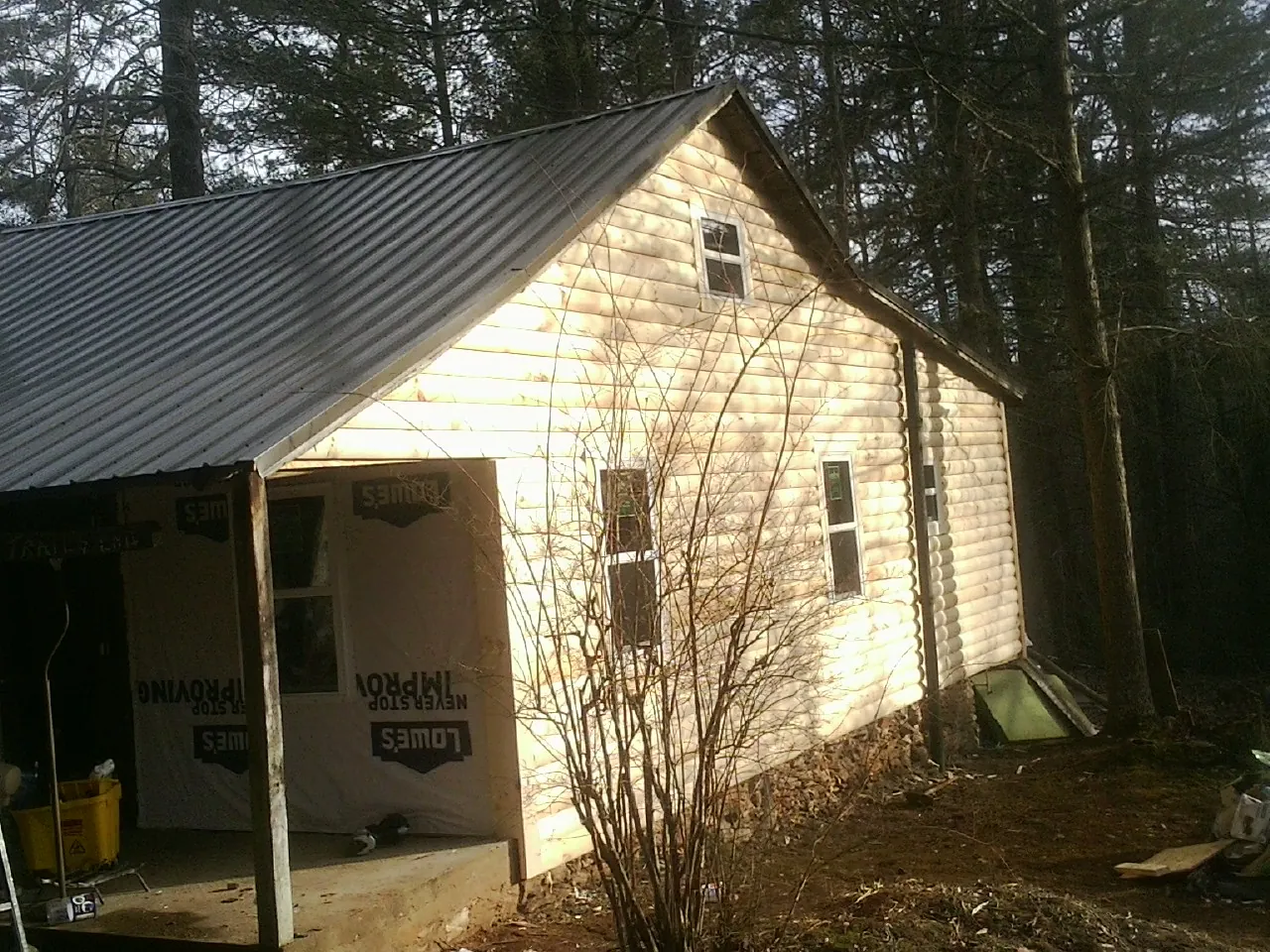 Log siding gable end under a dark metal roof edge in Bellevue