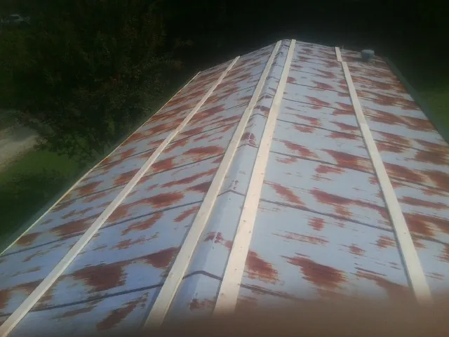 Rusted metal roof panels with new wood purlins before replacement — Storm Damage Roof Repair in Bellevue by Roofing Brothers